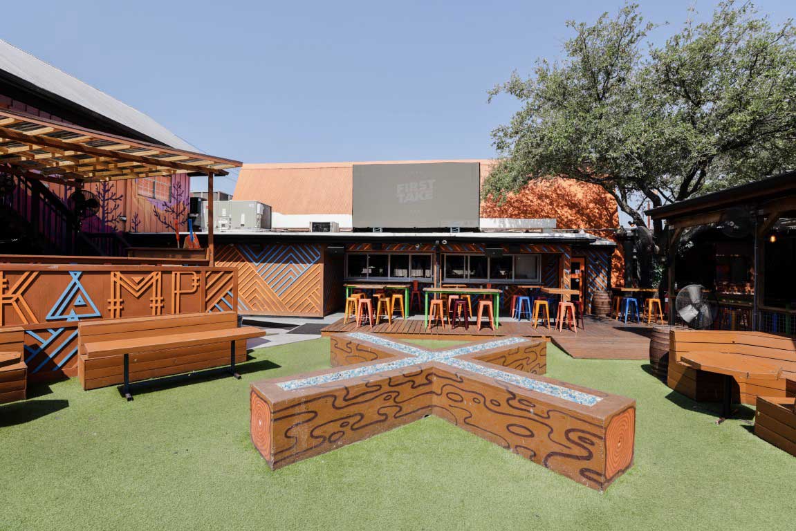 KAMP Houston patio seating area with tables, chairs, turf, and outdoor restaurant furniture